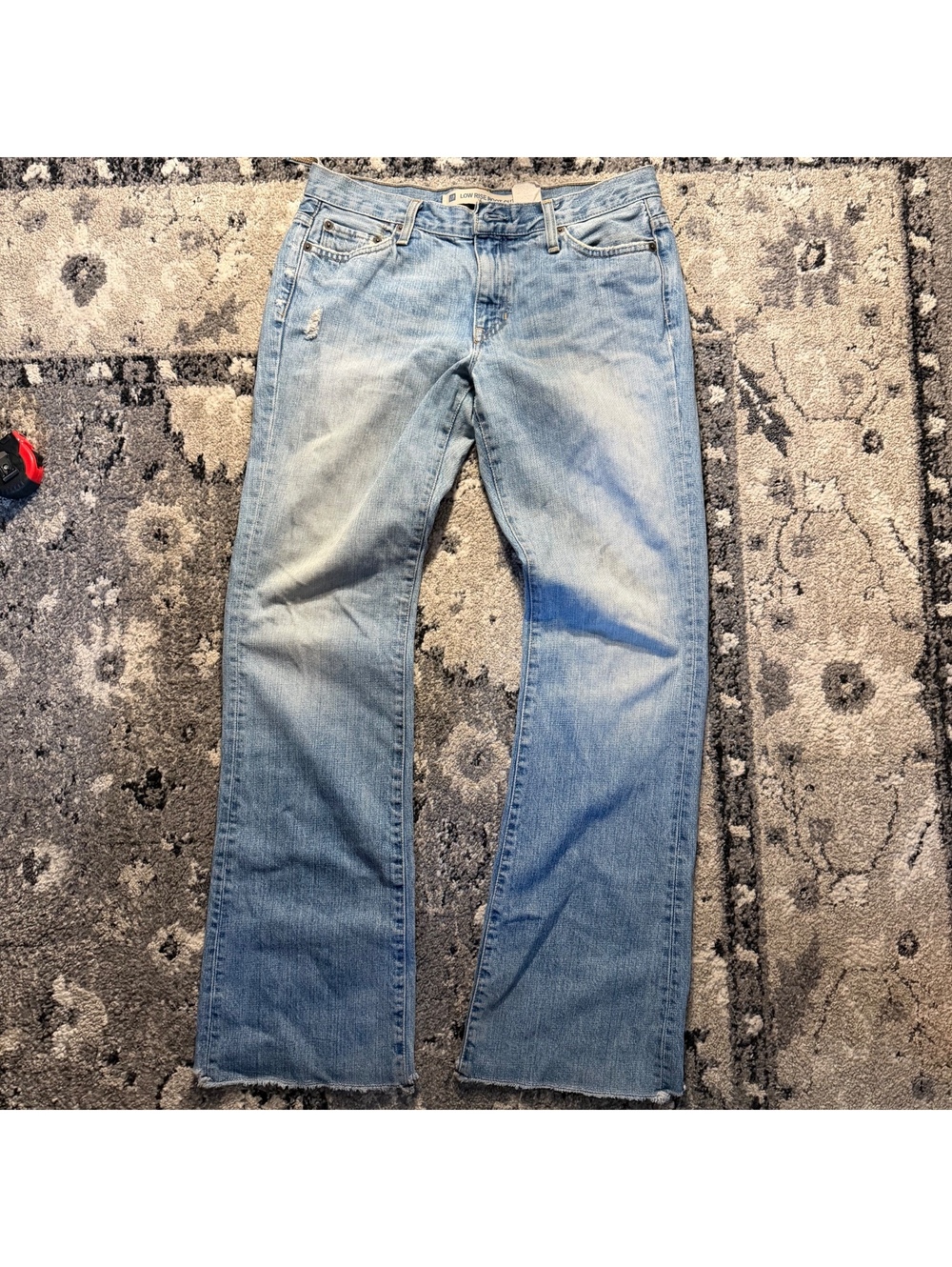 Low Rise Boot Cut Light Wash Blue Denim Jeans with Raw Hem